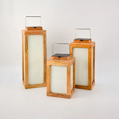 Set of three wood lanterns in different sizes with metal handles crafted from natural wood and frosted glass.