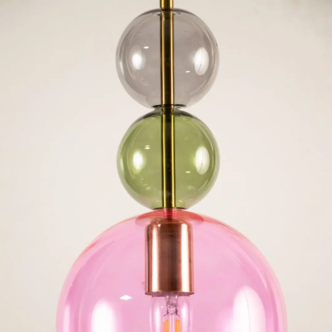 Green pink and smoke glass pendant light closeup highlighting artistic glass detailing and contemporary lighting design.