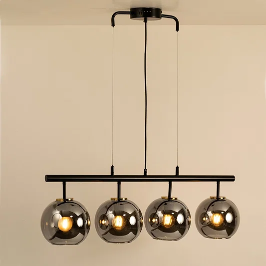 Smoked glass globe chandelier with black metal frame creating warm ambient lighting for modern dining room interiors.