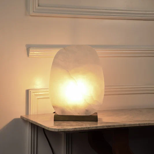 Marble effect globe table lamp with glowing stone shade creating soft ambient lighting for luxury interior decor.