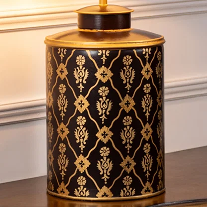 Table lamp closeup showcasing intricate black and gold pattern on ceramic base with detailed craftsmanship and glossy surface.