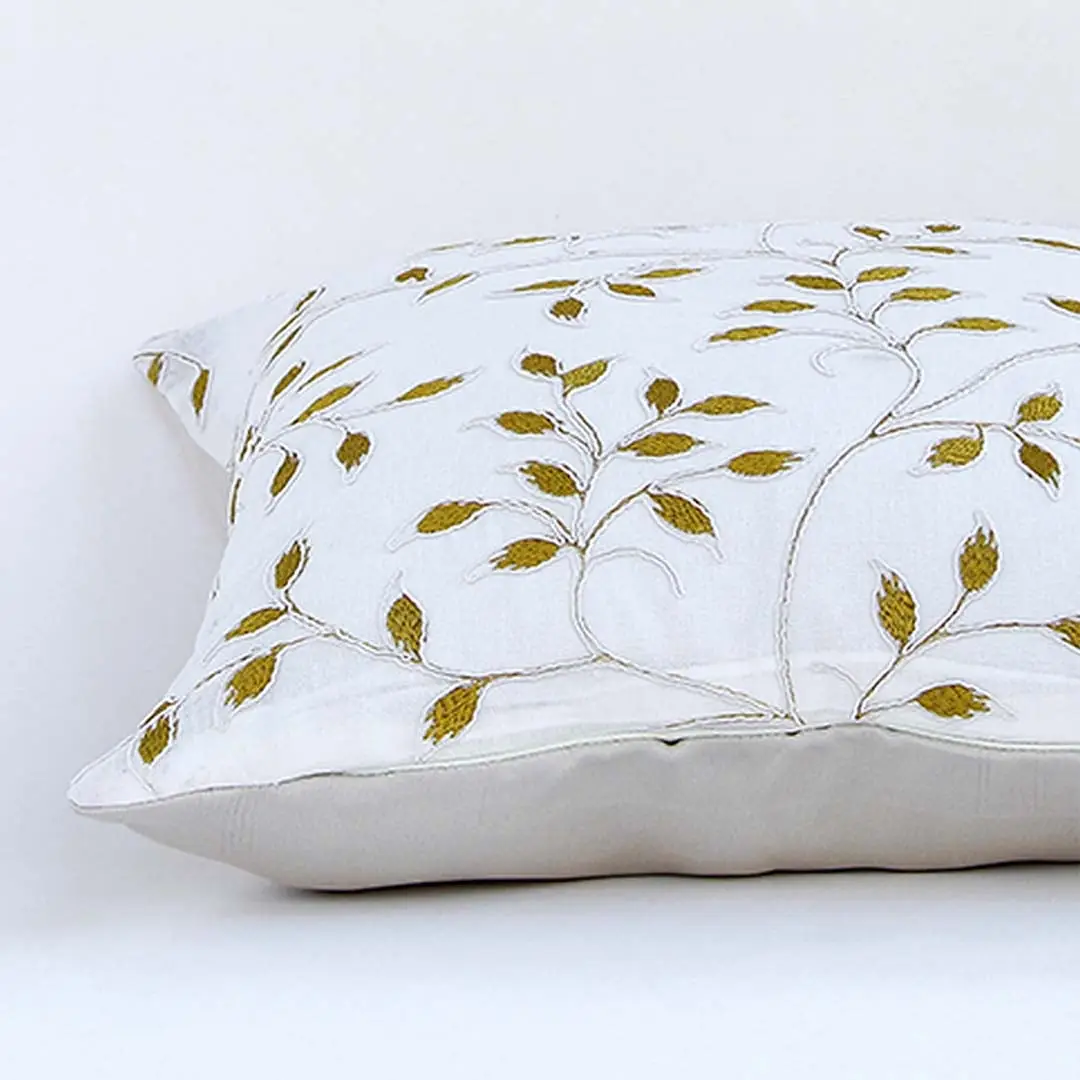 White cotton cushion cover with golden leaf embroidery in a rectangular form adding an elegant natural décor detail with a soft comfortable and skin friendly material.