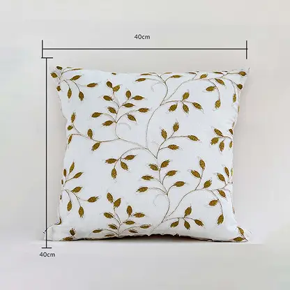 White cushion cover with golden leaf design displayed with guides showing its exact 40 cm x 40 cm size perfect for elegant home décor styling and modern interior accents.