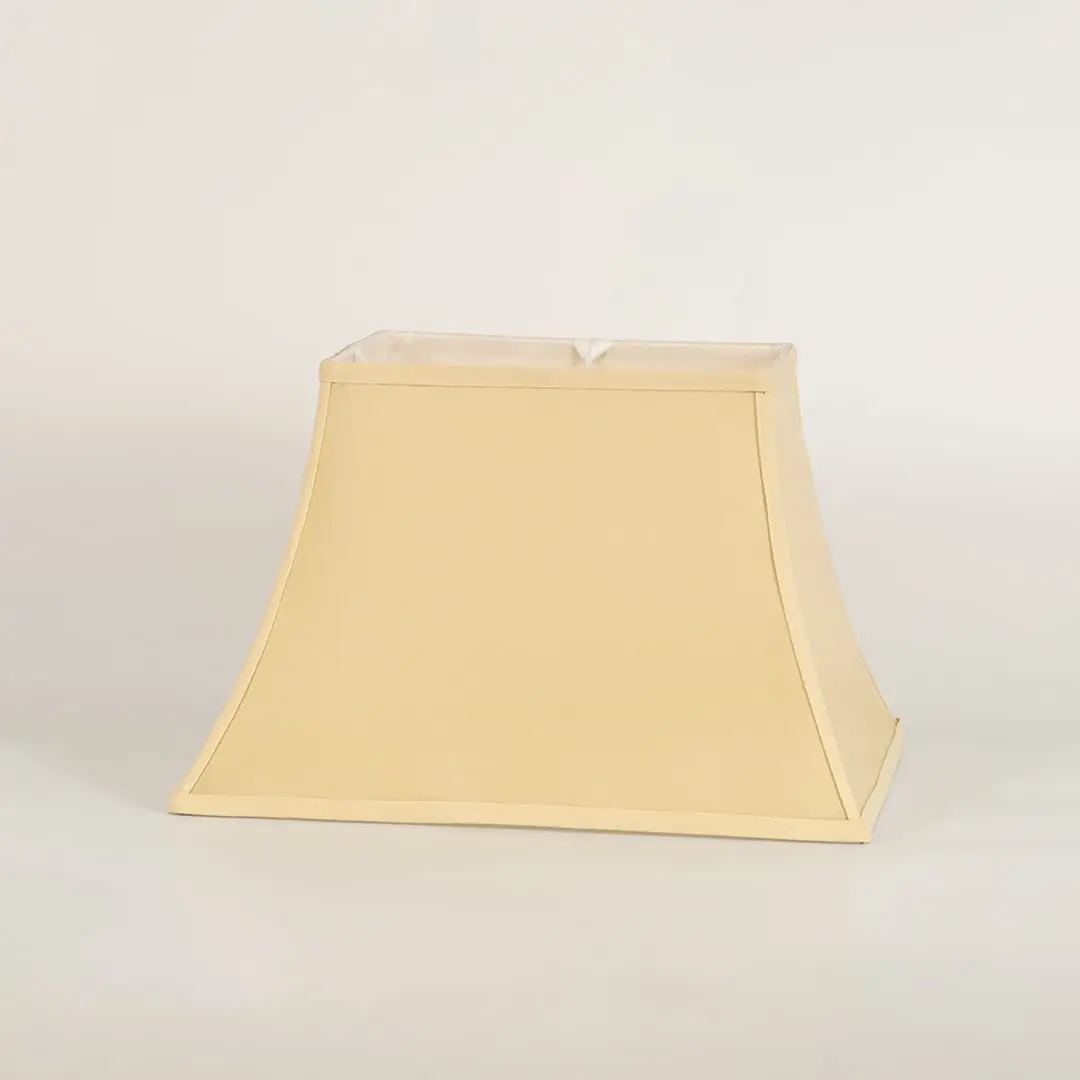 Cream bell shaped lamp shade shown in close up view on plain background for classic elegant lighting décor.