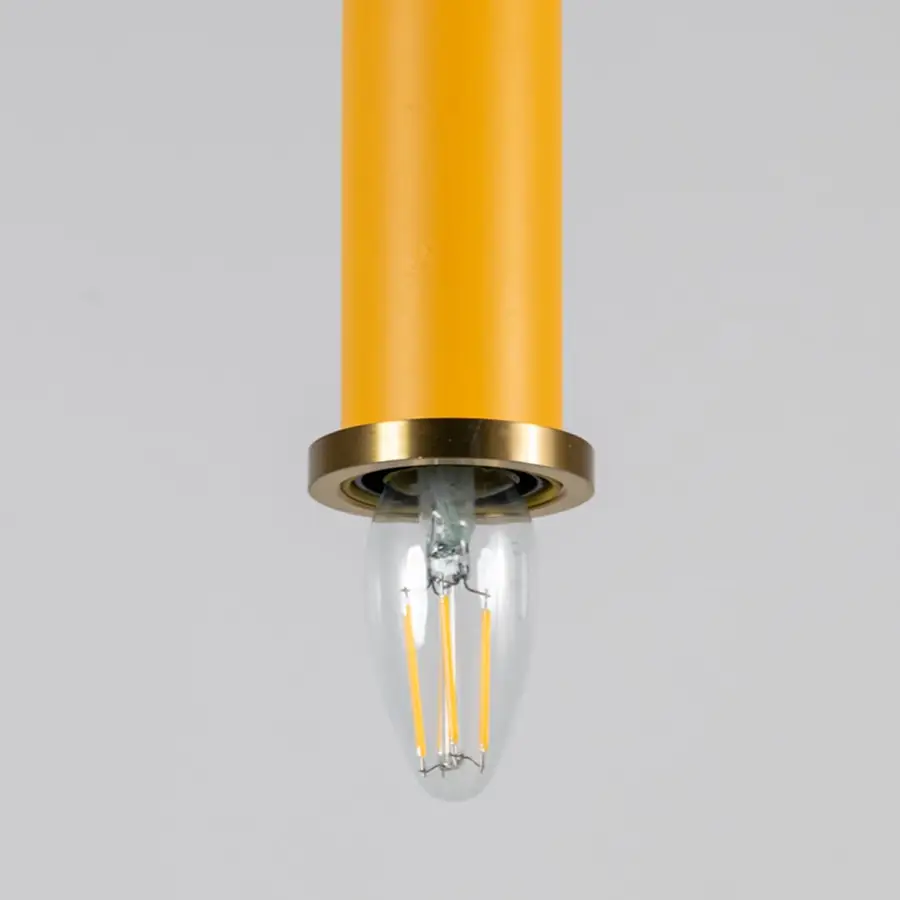 Yellow metal pendant light with brass detailing showcasing sleek cylindrical form and modern Scandinavian style appeal.