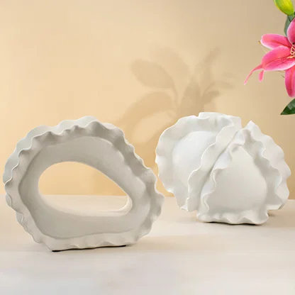 Set of white ceramic decorative bowls with sculptural organic forms for elegant shelf styling and modern home decor.