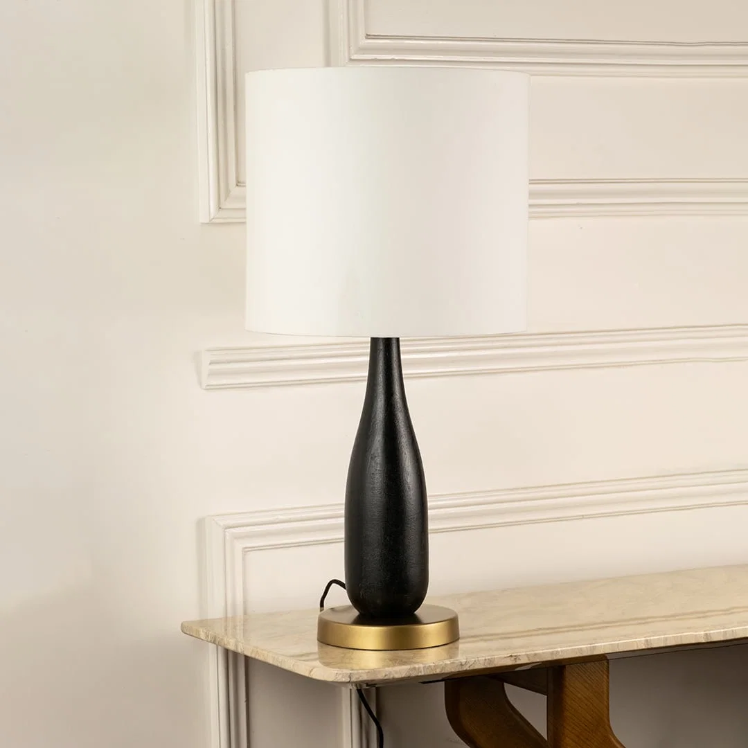 White fabric shade table lamp with black wood base and brass accents for elegant bedside and console table decor.