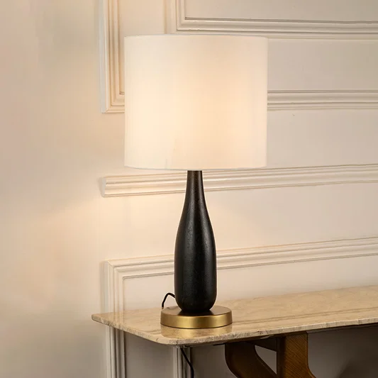 Table lamp with sleek black base and minimal design ideal for modern bedroom or living room table decor on clean background.