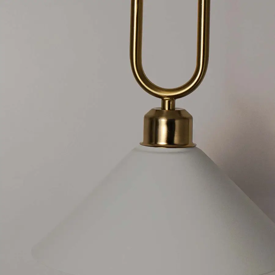 Closeup of white metal pendant light with polished gold loop detailing showcasing refined craftsmanship and elegance.