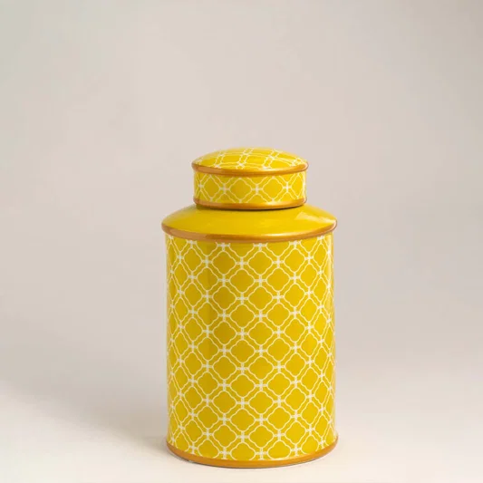 Yellow ceramic decorative storage jar with textured pattern and lid for elegant shelf styling and modern home decor.