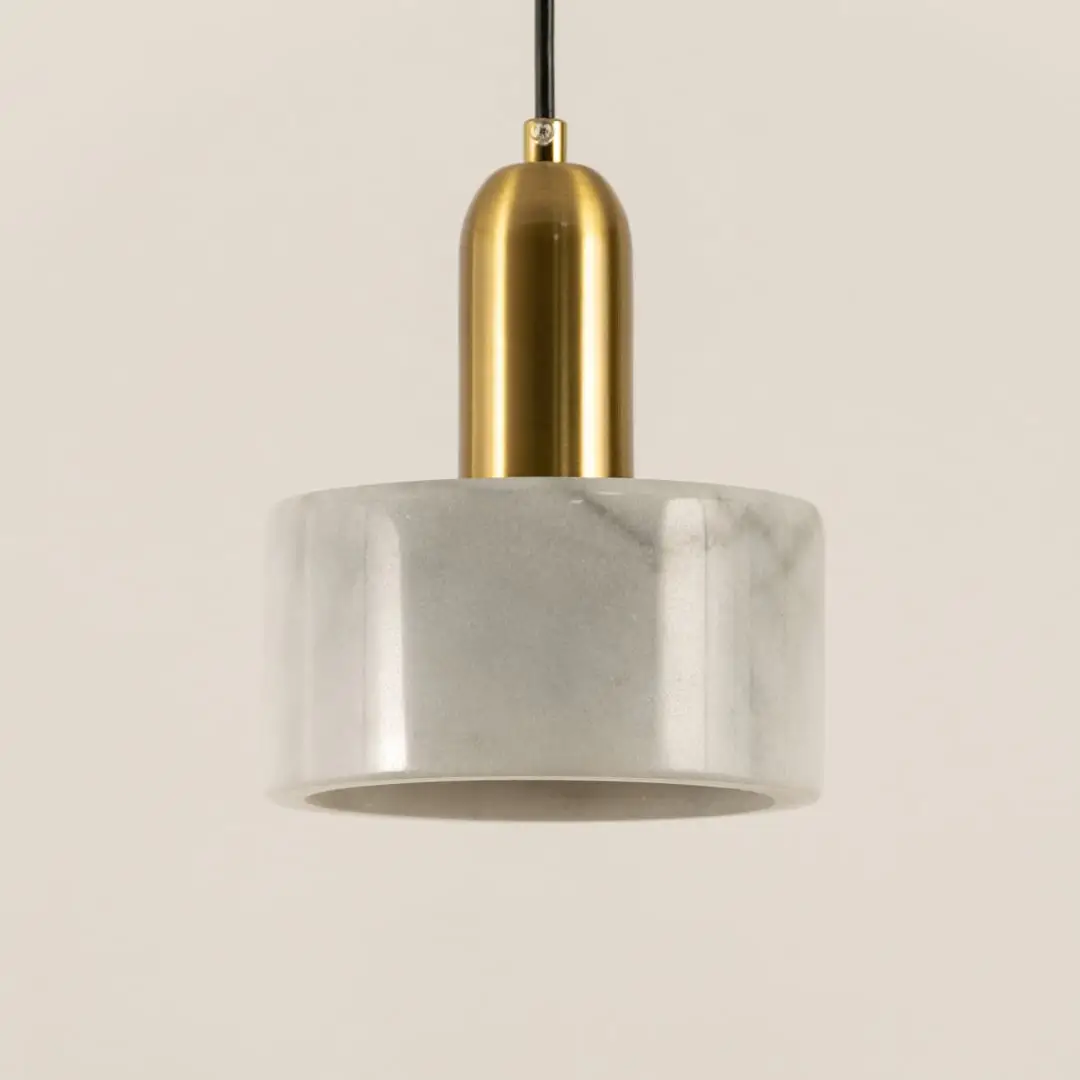 Closeup of white marble pendant light with brushed gold details showcasing premium craftsmanship.