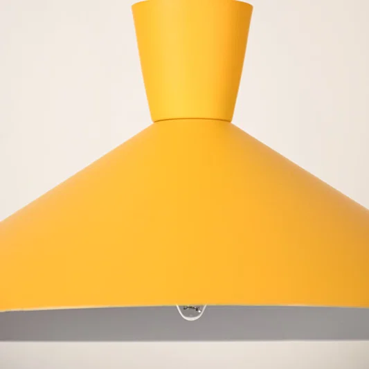 Yellow metal pendant light illuminated to showcase modern ceiling lighting with warm decorative elegance and style.