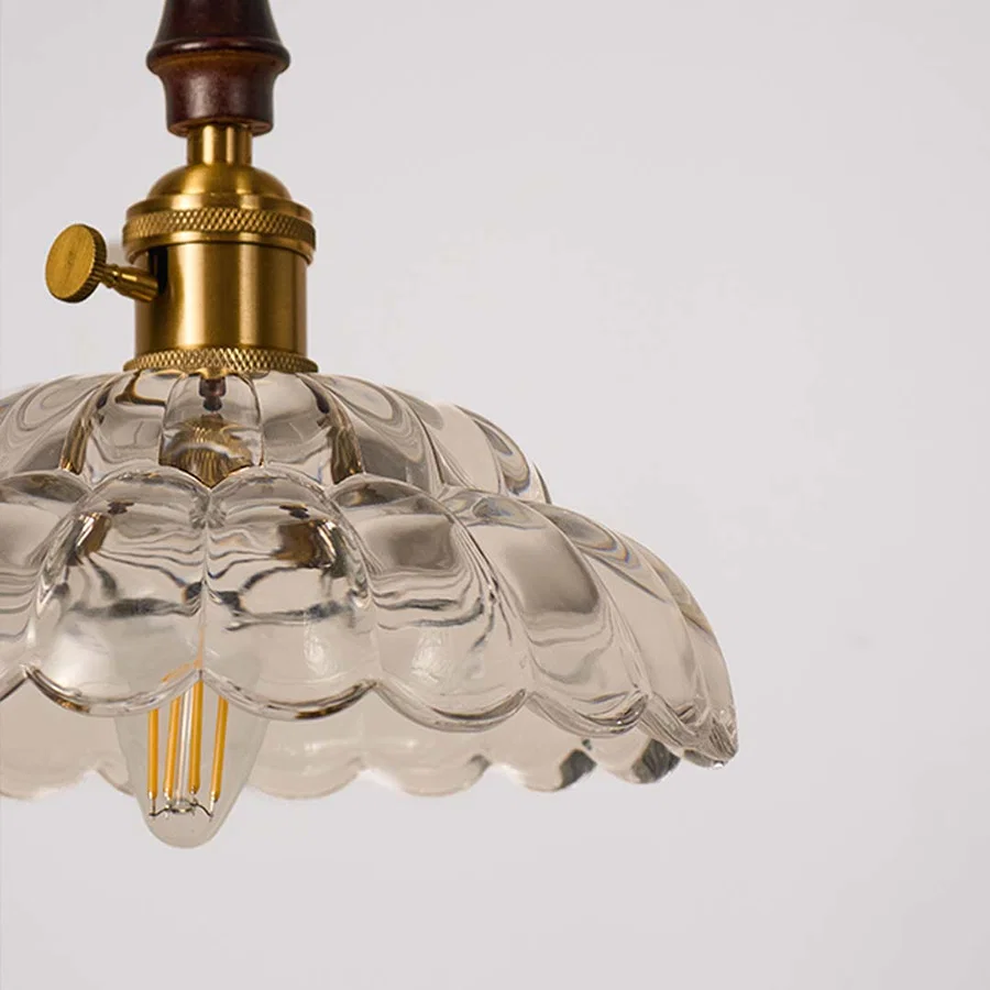Closeup of textured clear glass and brass metal pendant light showcasing premium detailing.