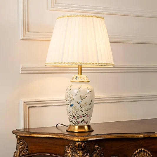 White floral ceramic table lamp with pleated fabric shade adding elegant traditional decor and ambient lighting indoors.