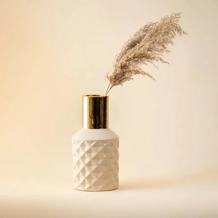 Textured white vase with gold neck and pampas grass for sophisticated home decor and interior styling.