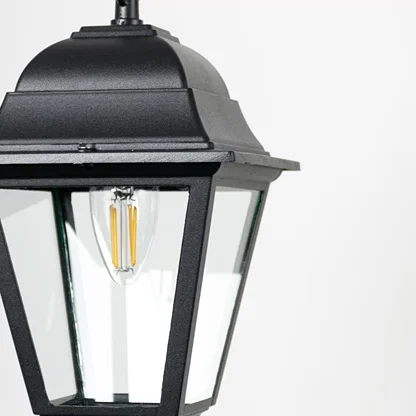 Closeup of outdoor hanging lantern light showing bulb detail and refined black metal finish.