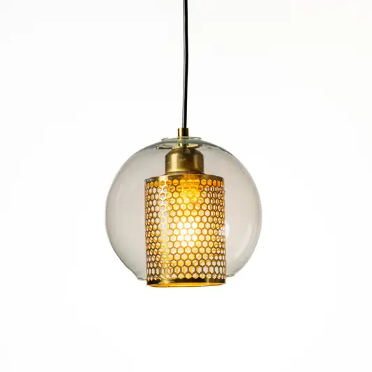 Contemporary round clear glass pendant lamp with exposed filament bulb and metal holder hanging against minimal neutral background ideal for modern interiors.