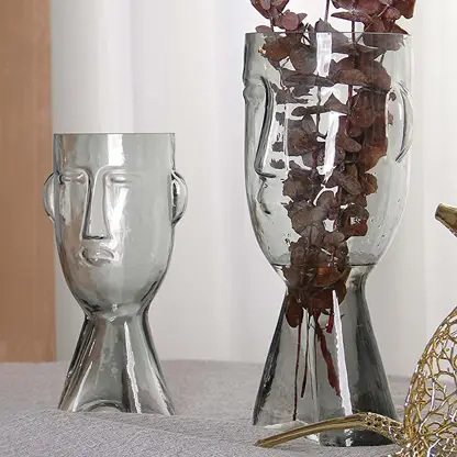 Set of abstract face design glass vases in clear finish artistic decorative modern style light on white background for display.