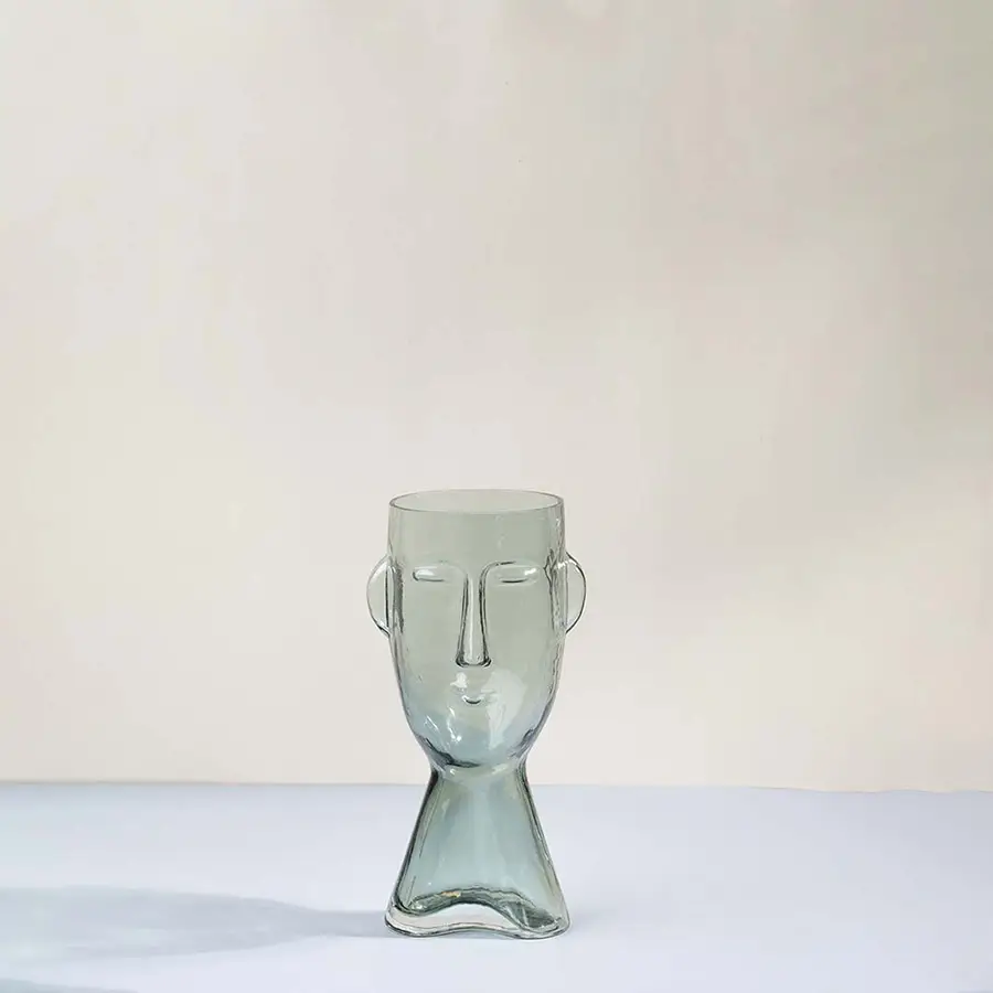 Light green glass decorative vase with sculptural face design for tabletop styling and modern home decor displays.