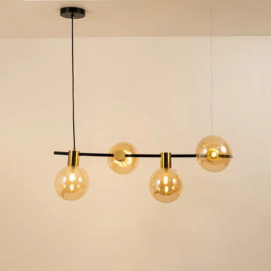Amber glass globe chandelier with gold and black metal frame creating warm modern ceiling lighting for dining spaces.