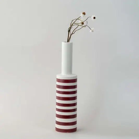 A tall modern striped vase captured in a soft lifestyle setup showcasing its slim neck bold bands and elegant height for contemporary home styling.