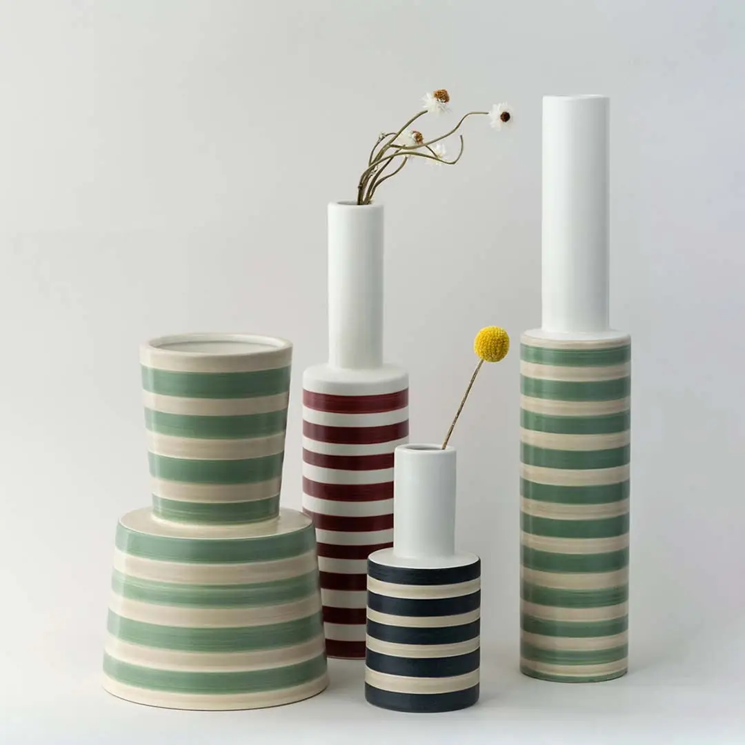 Set of striped ceramic vases in green red and black designs grouped together perfect for creating a coordinated modern home decor display.