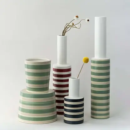 Set of striped ceramic vases in green red and black designs grouped together perfect for creating a coordinated modern home decor display.