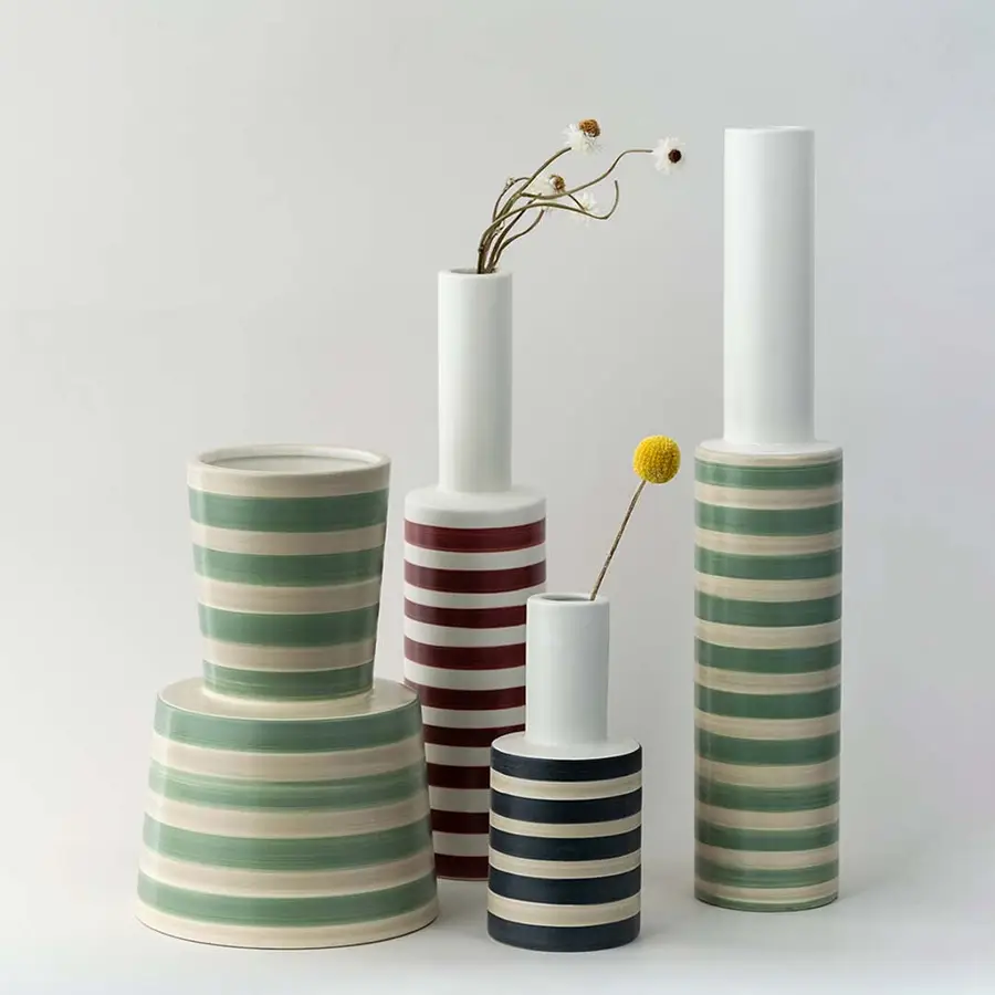 Set of striped ceramic vases in green red and black designs grouped together perfect for creating a coordinated modern home decor display.