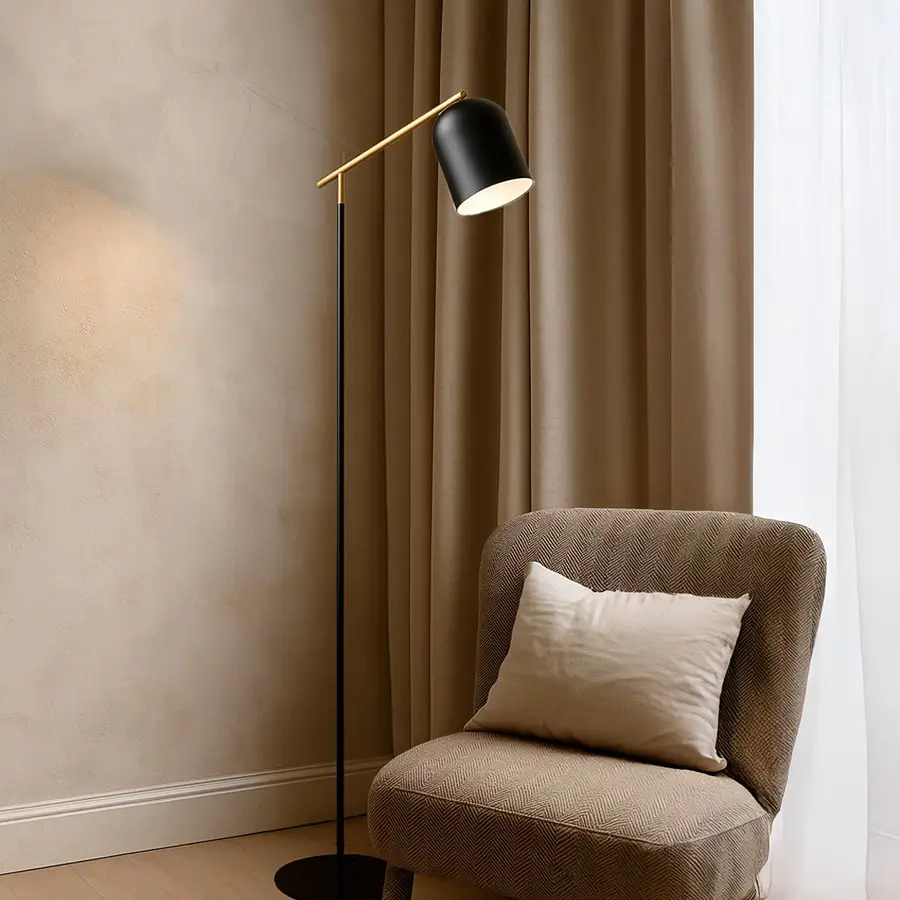 Angled floor lamp with gold arm and black shade shown on white background for contemporary lighting product display