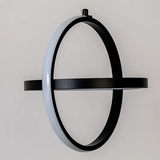Closeup wall light in black metal finish with oval frame design for bedroom or living decor lighting white background.