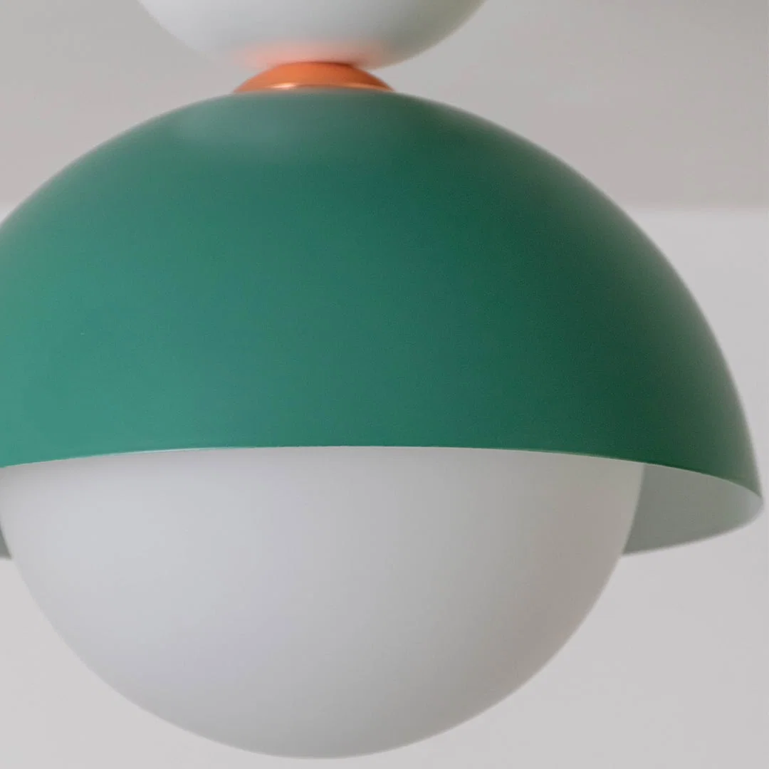 Closeup view of the green dome ceiling light highlighting its smooth finish and round white globe design.