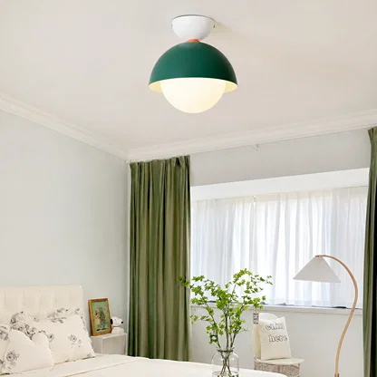 Modern ceiling light in a soft room setting with a green dome shade and a round white globe for gentle ambient lighting.