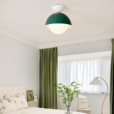 Modern ceiling light in a soft room setting with a green dome shade and a round white globe for gentle ambient lighting.