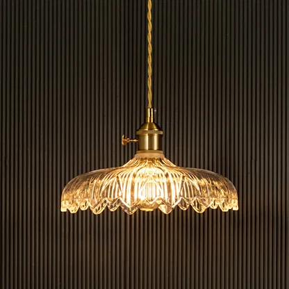 Crystal glass pendant light with brass frame illuminated for sophisticated ceiling decor.