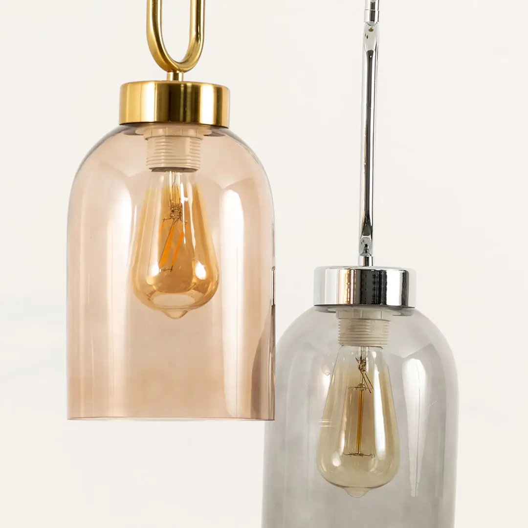Amber and smoke glass pendant lights illuminated to showcase elegant modern ceiling lighting with decorative appeal.