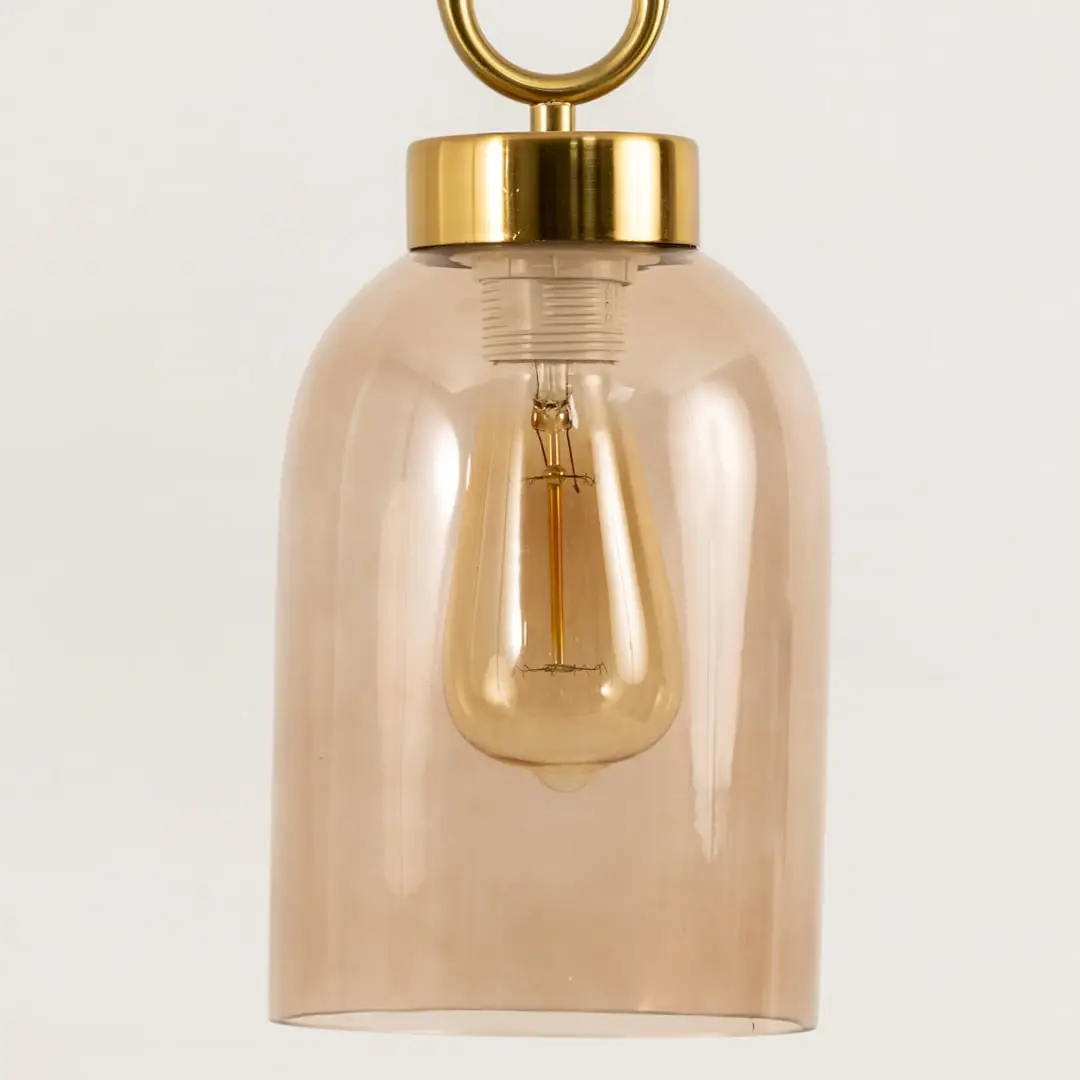 Amber glass pendant light closeup highlighting smooth glass finish and premium contemporary lighting craftsmanship details.