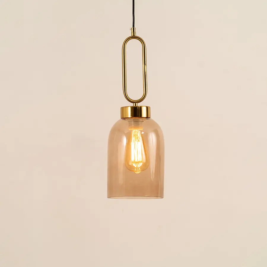 Elegant amber glass pendant light with gold metal accents for stylish dining room and kitchen decor styling.