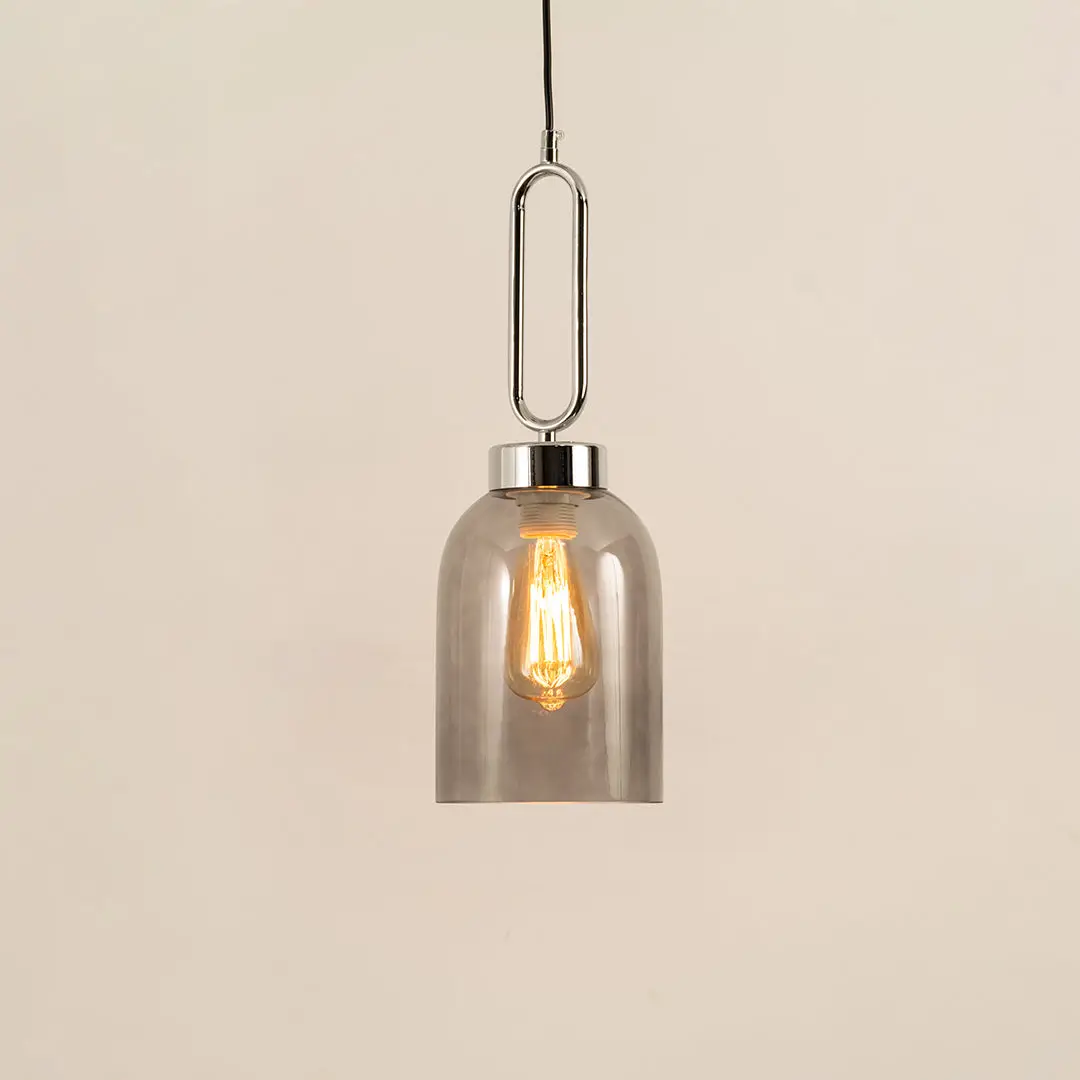Modern smoked glass pendant light with black metal accents for elegant dining room decor styling.