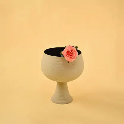 Elegant ribbed beige metal pedestal vase with flower for luxury home decor and sophisticated tabletop centerpiece style.