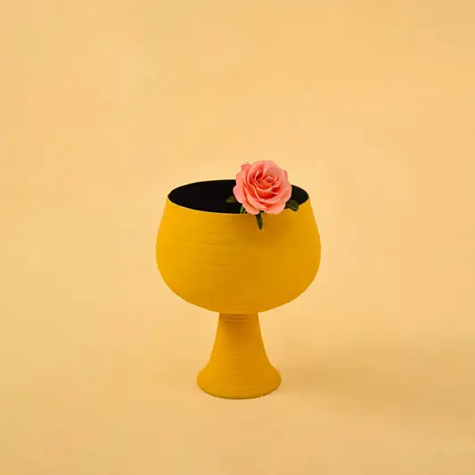 Yellow metal pedestal bowl decor styled in a warm modern space adding a bold accent to living room tables and shelves.