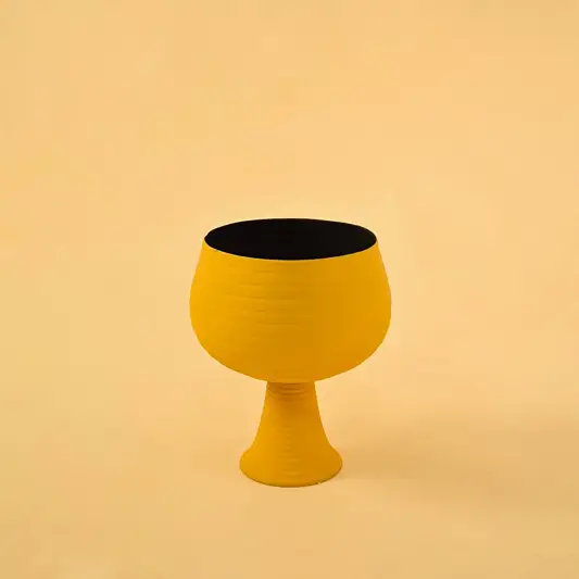 Yellow metal pedestal bowl decor on a clean white background highlighting its bold modern textured design for home styling.
