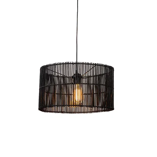 Black metal pendant light with wide drum cage design and visible warm bulb hanging against soft neutral wall background for modern industrial decor.