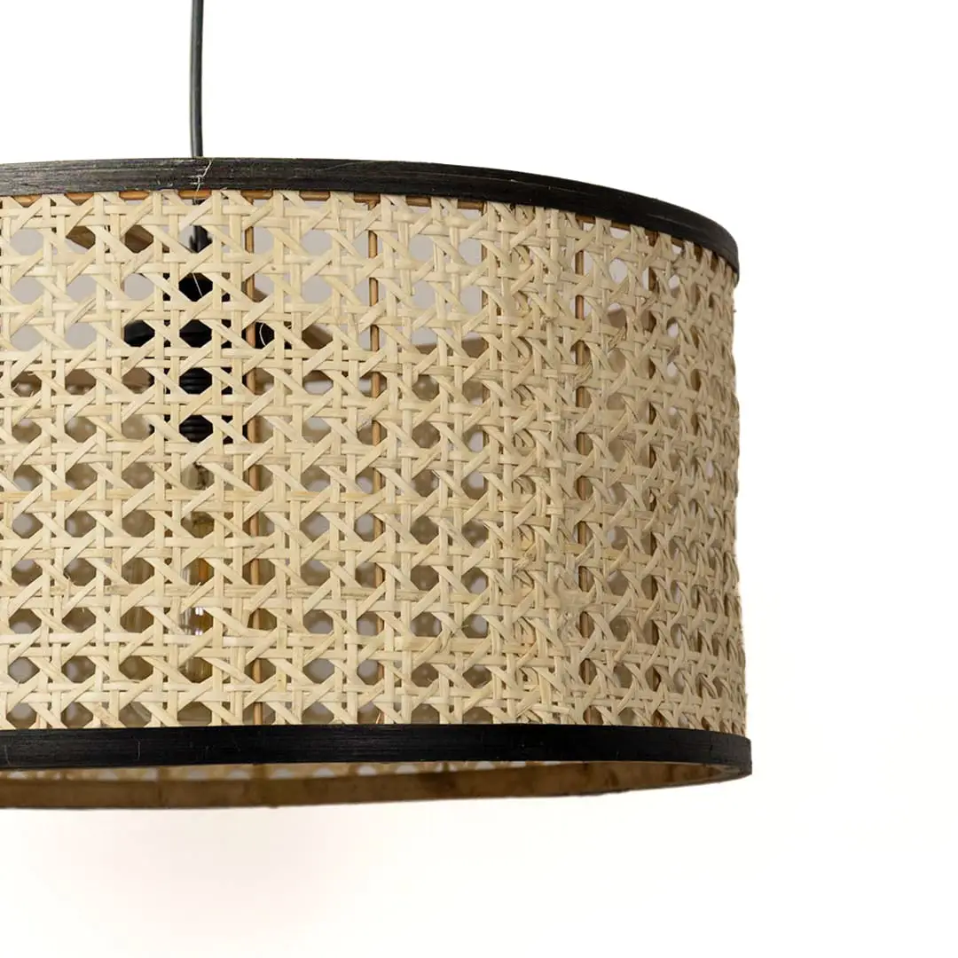 Detailed view of woven rattan drum shade with black trim highlighting artisan craftsmanship.