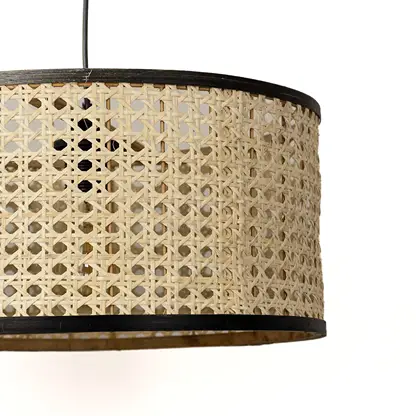 Detailed view of woven rattan drum shade with black trim highlighting artisan craftsmanship.