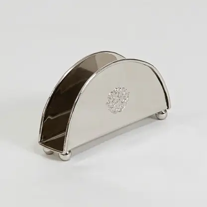 Modern metal napkin holder in silver finish for dining table or kitchen decor accessory placement white background.
