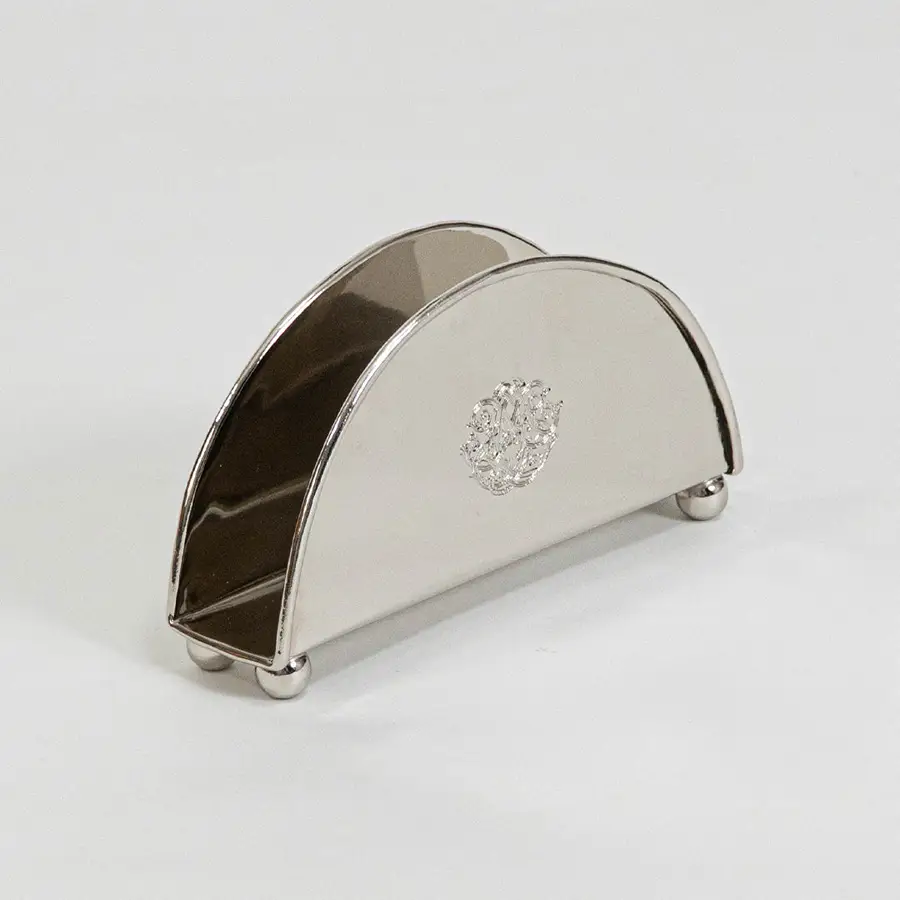Modern metal napkin holder in silver finish for dining table or kitchen decor accessory placement white background.