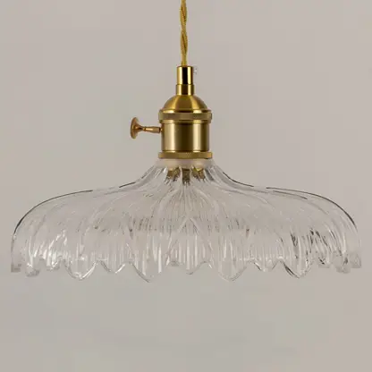 Clear textured glass pendant light with gold metal fixture illuminated to showcase elegant decorative ceiling lighting.