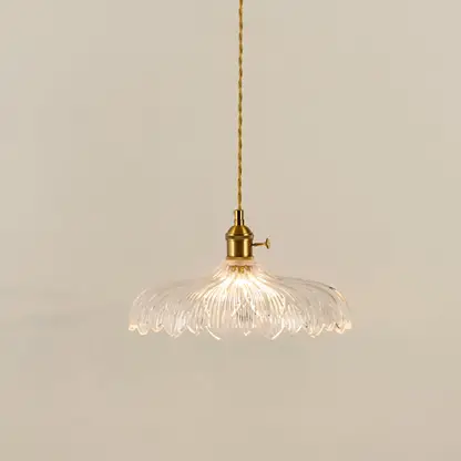Gold metal pendant light with textured glass shade illuminated to showcase elegant decorative ceiling lighting appeal.