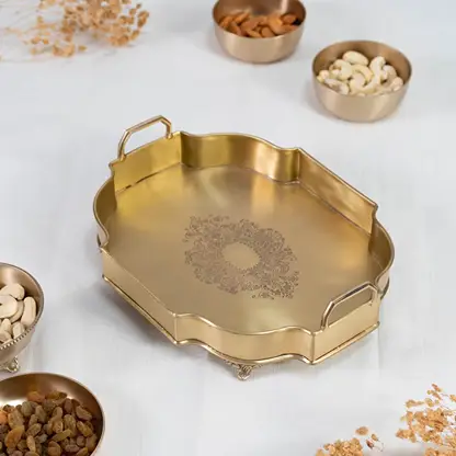 Octagonal antique gold brass tray with floral engraved center and upright handles displayed on white background.
