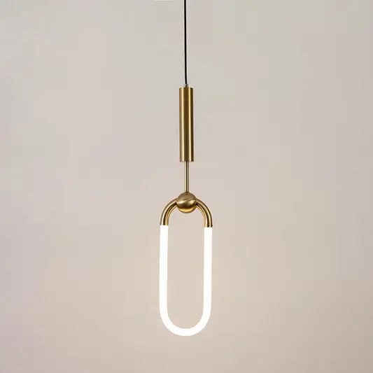 Gold metal pendant light with frosted acrylic loop illuminated to showcase minimalist contemporary ceiling lighting.
